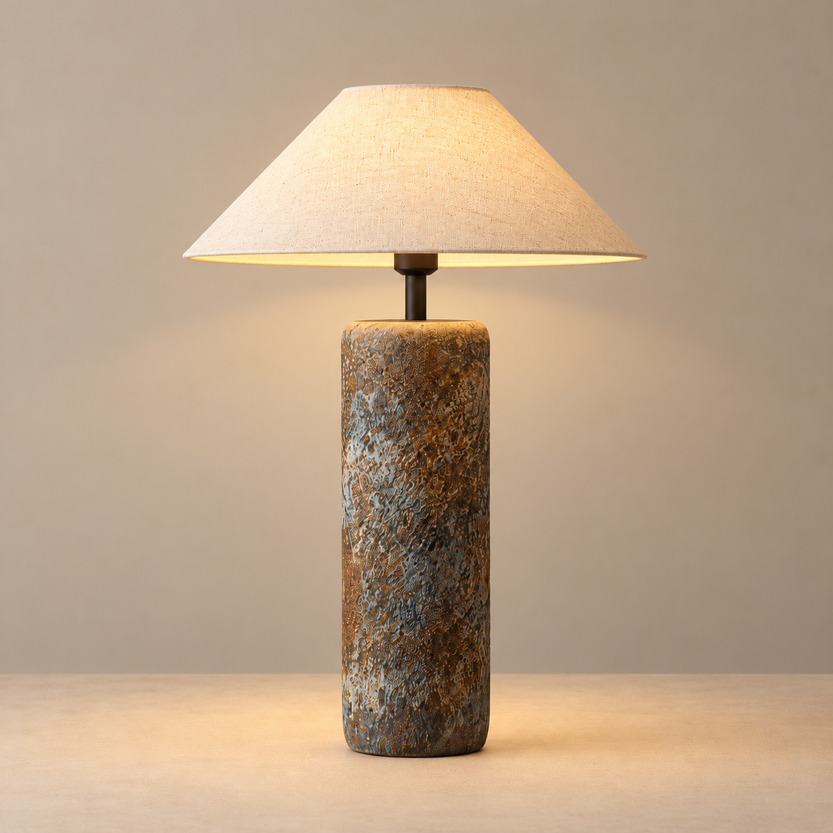 Large textured ceramic table lamp illuminated on a beige background