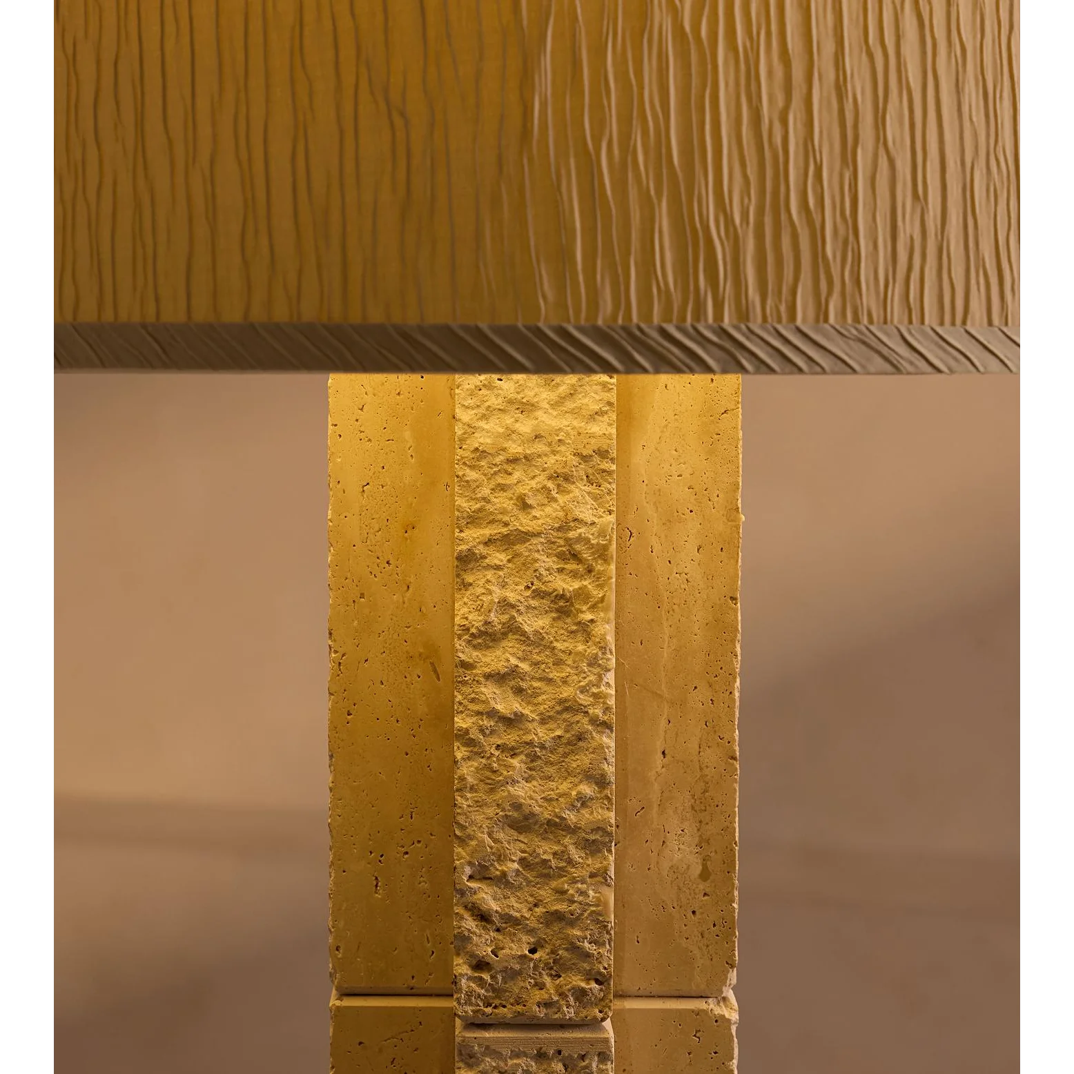 Travertine floor lamp glowing warm beside seating