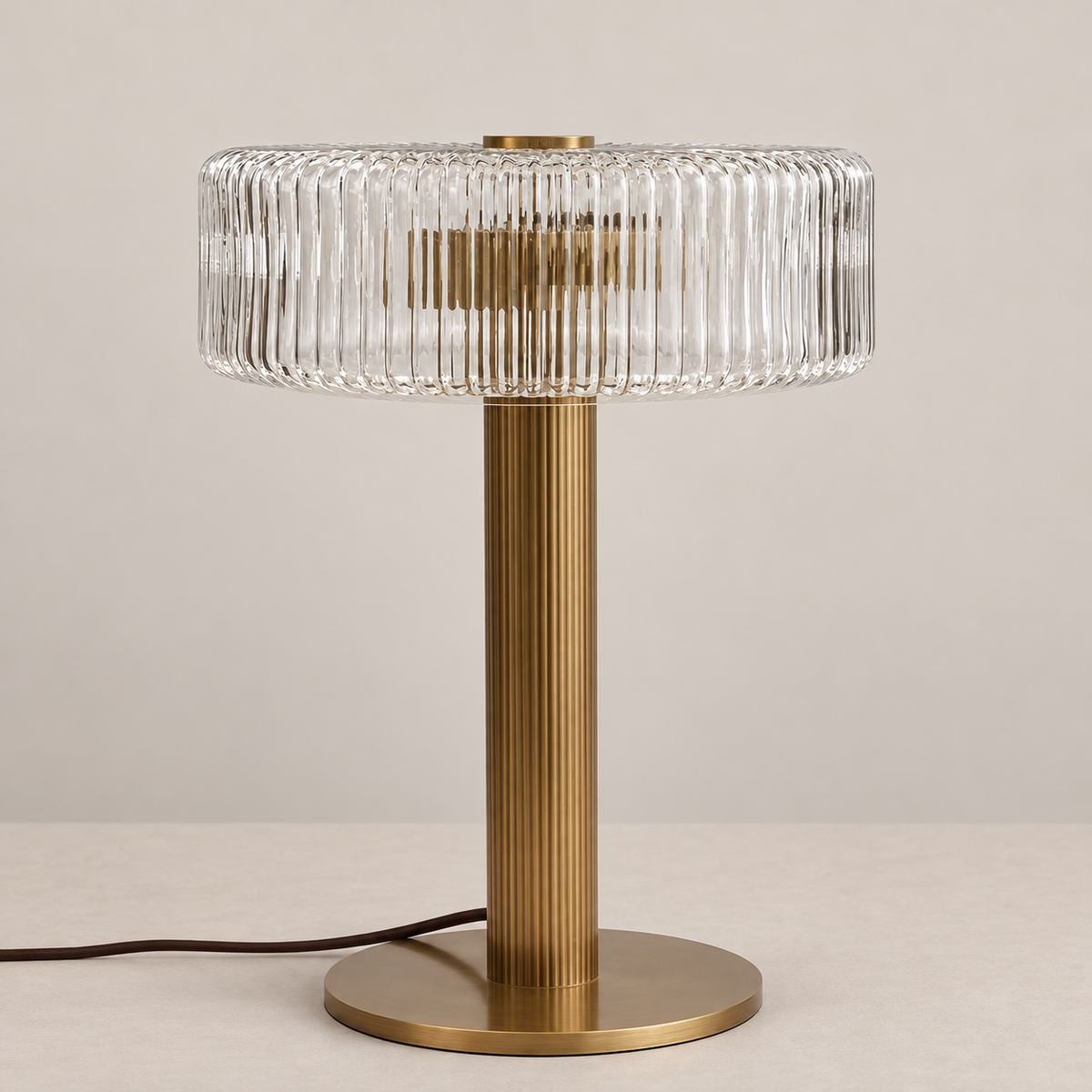 Ribbed clear glass table lamp with fluted brass stem, unlit