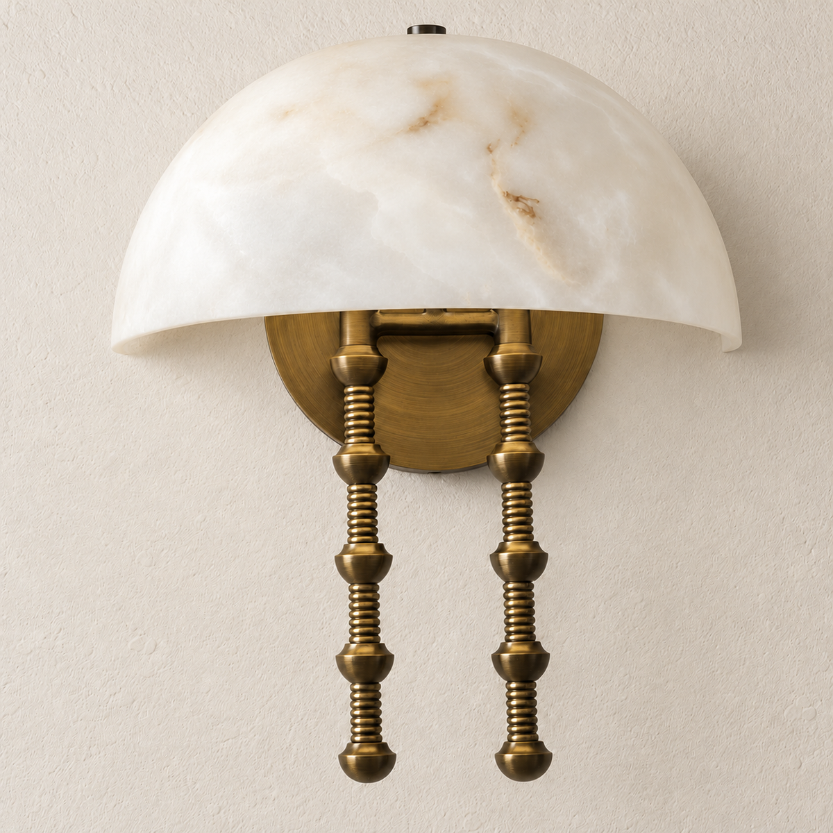 Low-angle view of the alabaster dome sconce showing its round brass backplate and two ribbed stems.