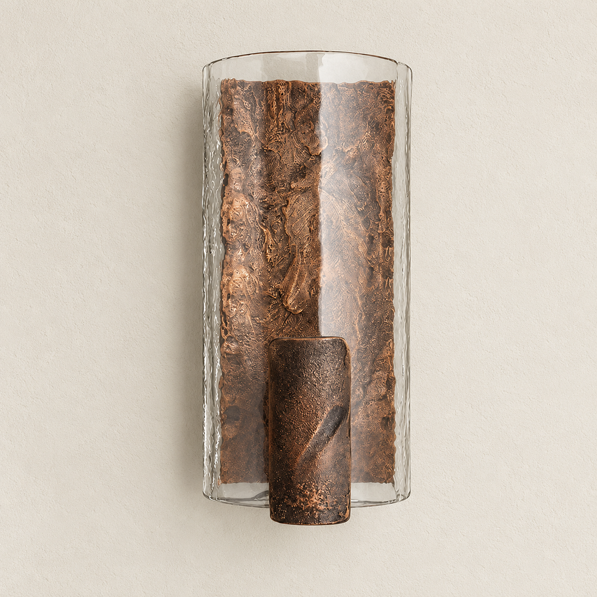 Unlit copper-finish wall sconce with a clear curved glass shade and textured cast-steel core on warm ivory.
