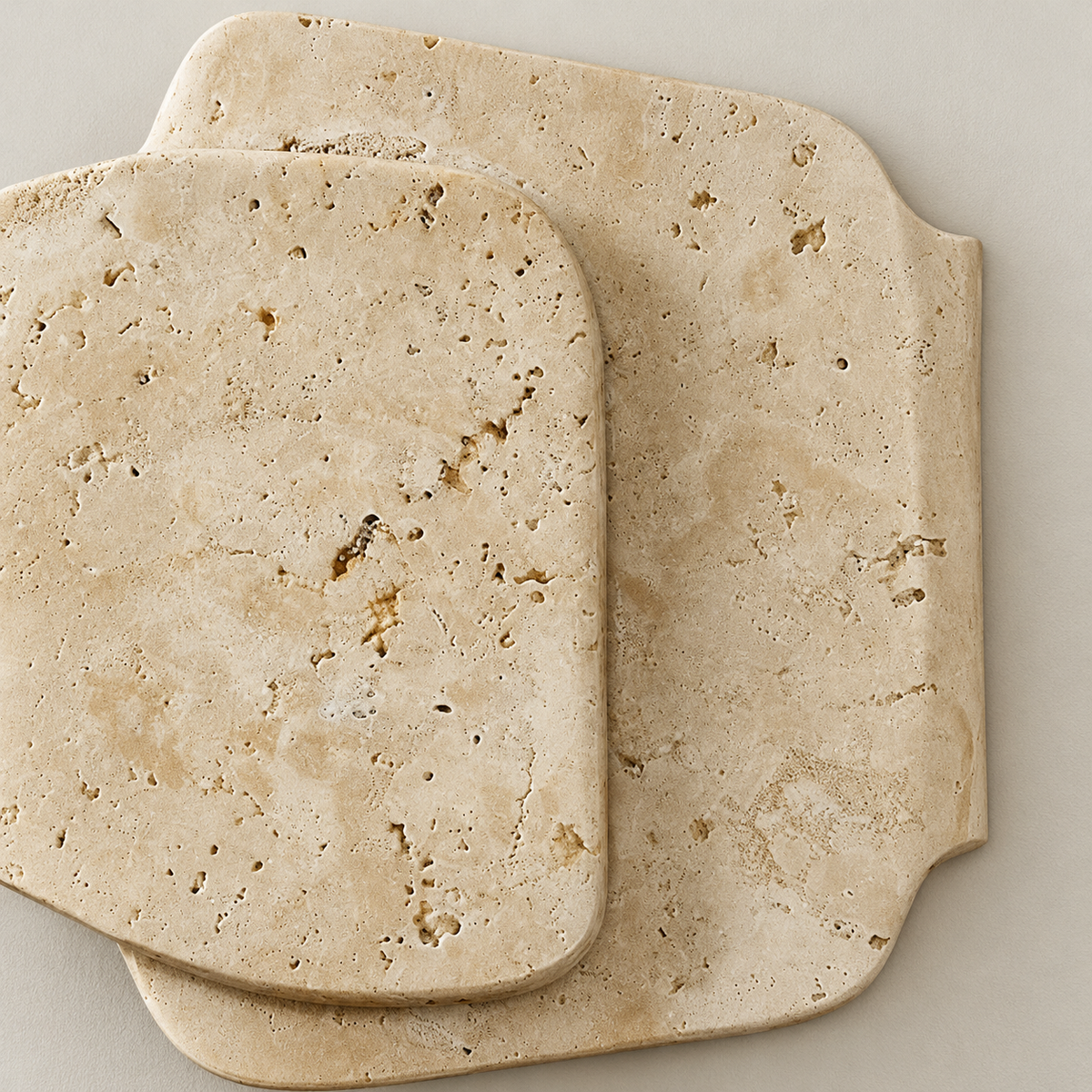 Close-up of the porous travertine surface and rounded edges of the two stone panels.