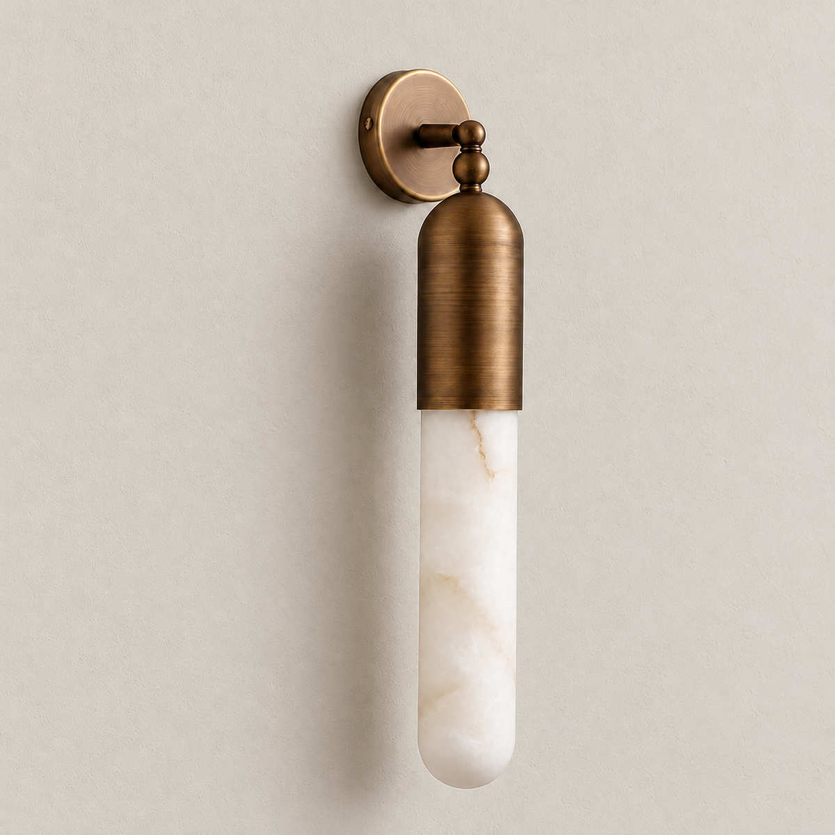 Three-quarter view of the alabaster tube sconce with its brass arm and round backplate.