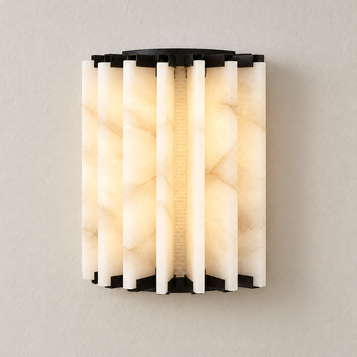 The same alabaster panel sconce illuminated, with soft light between the stone fins.