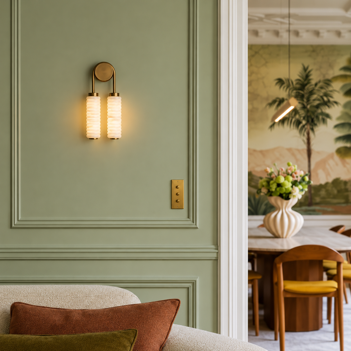 Double marble and brass wall sconce on a sage green wall beside a Parisian doorway.