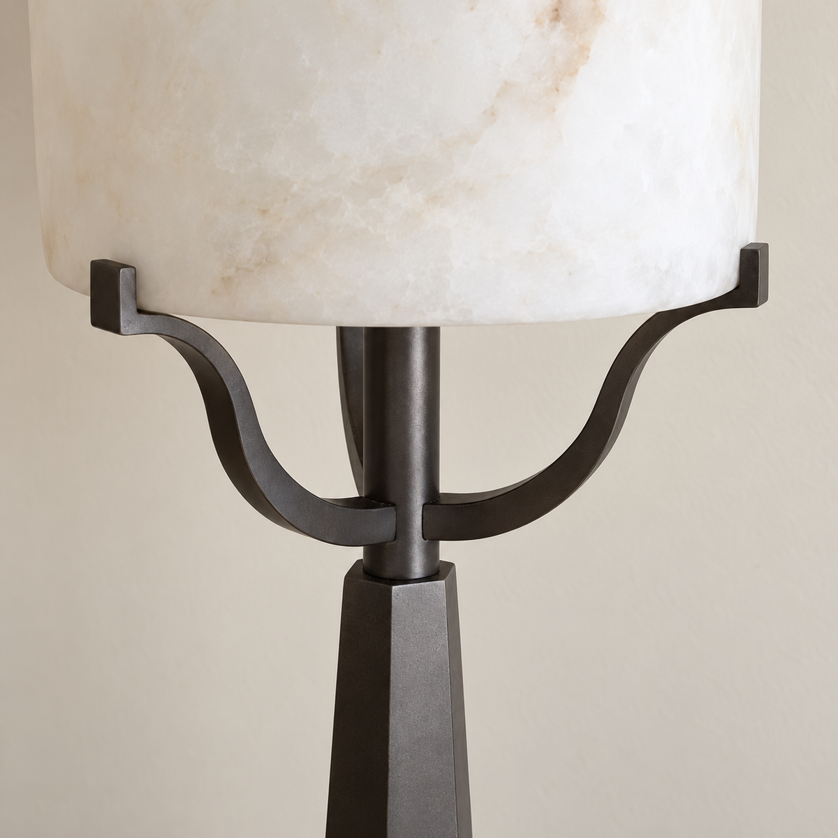 Close-up of the Svolti floor lamp's alabaster shade, curved iron supports and tapered column.