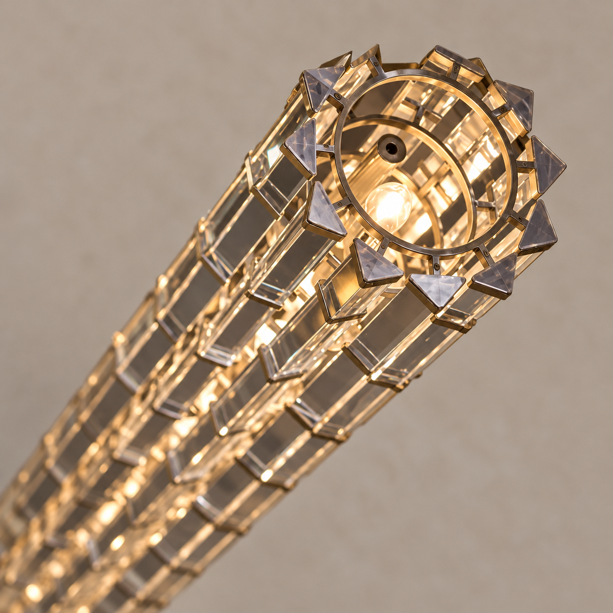 Oblique close-up of crystal prisms, gold mounting rings and the open top of the lamp.