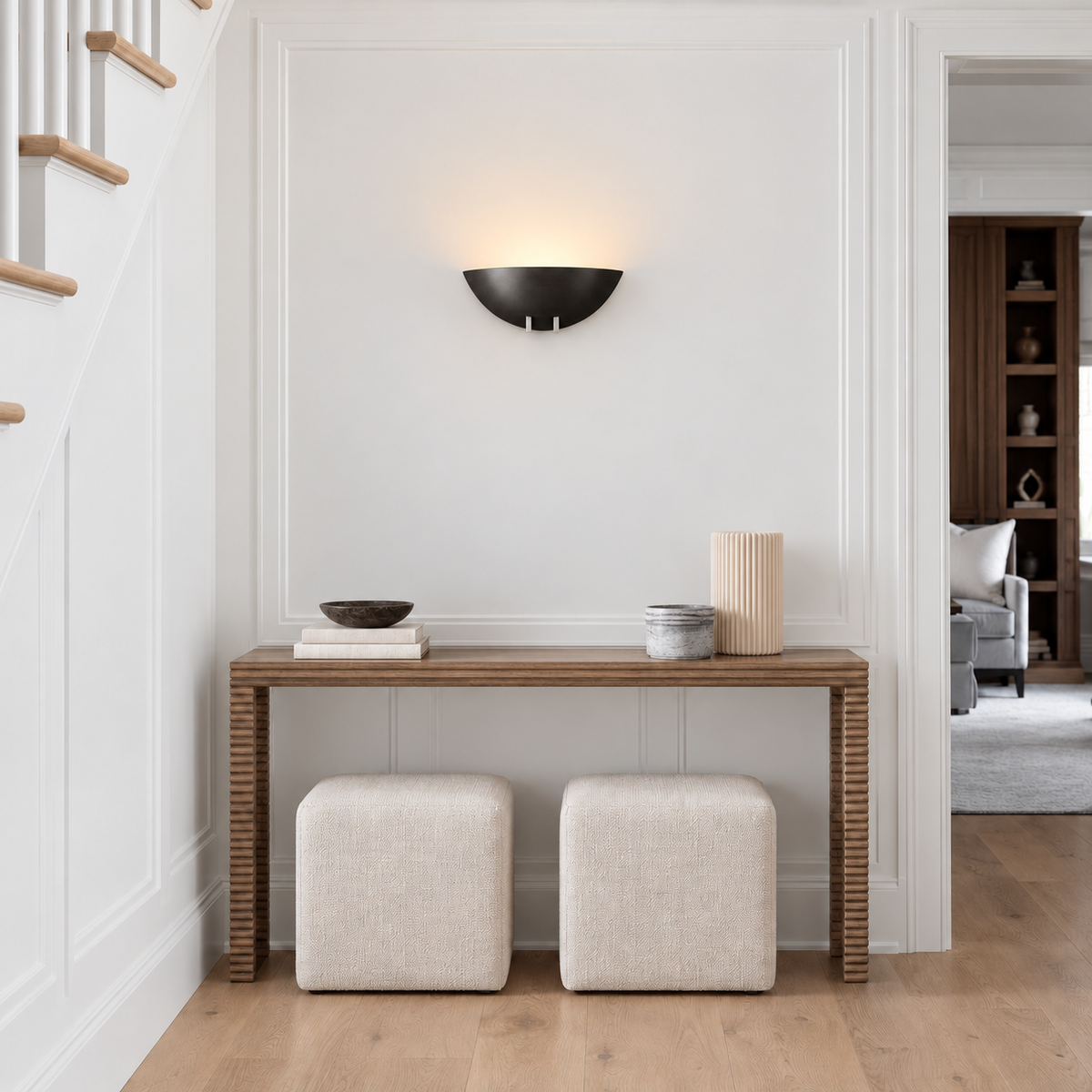 Black bowl wall sconce installed in an entryway.