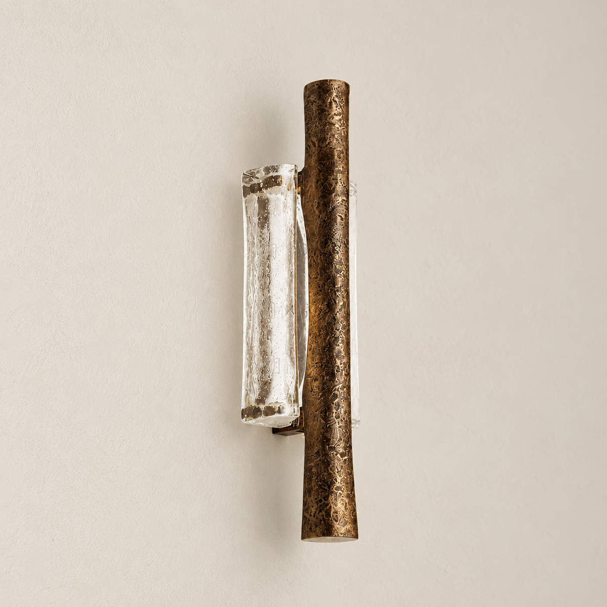 Angled view of textured brass wall sconce with clear curved glass.