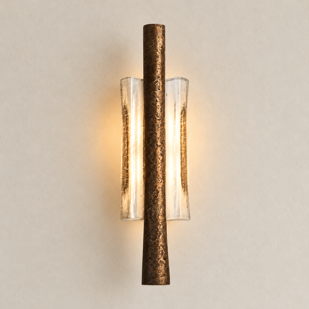 Textured brass wall sconce with clear curved glass illuminated in the matching ivory composition.