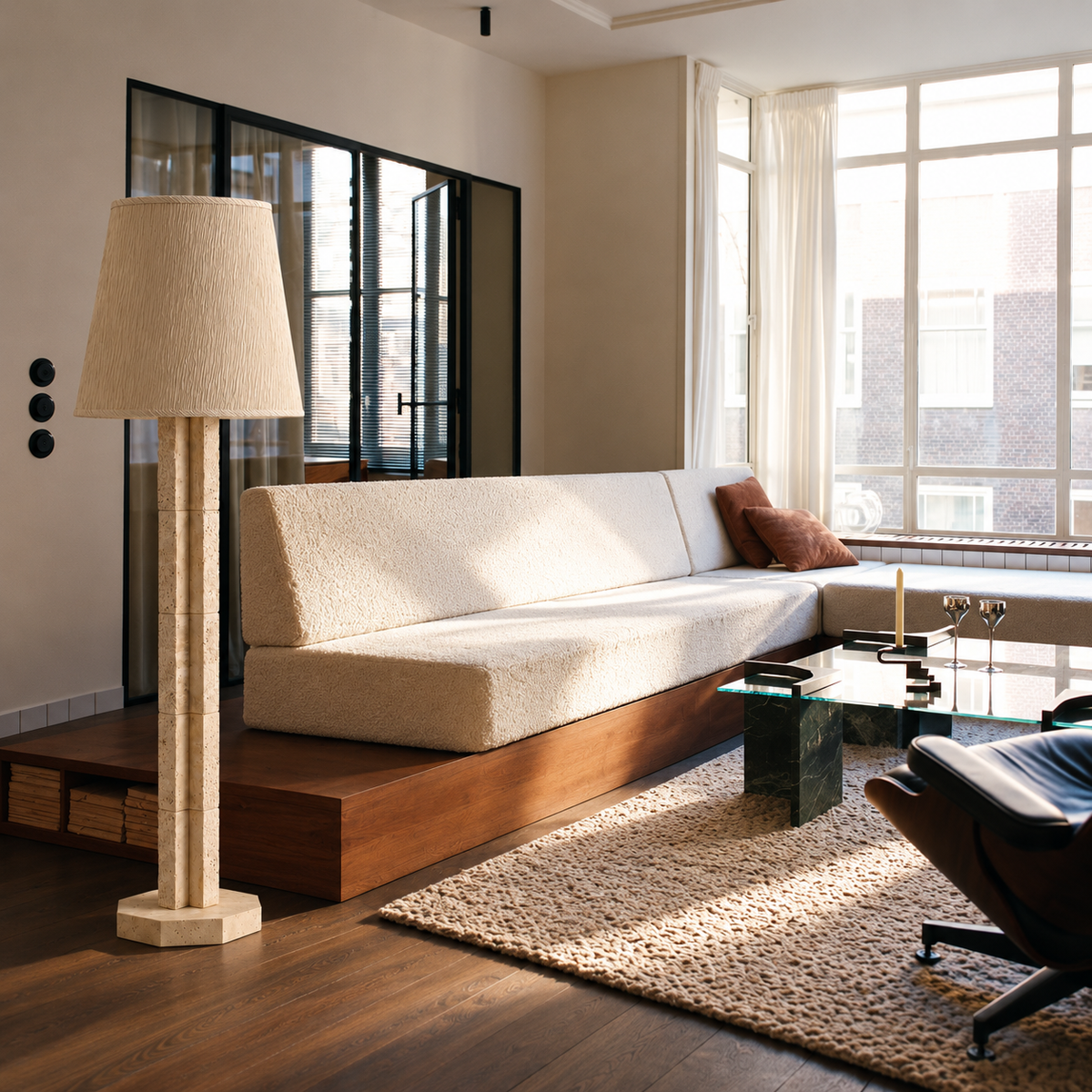 CLJFR53 travertine floor lamp beside a white sofa on a walnut platform in a bright living room.