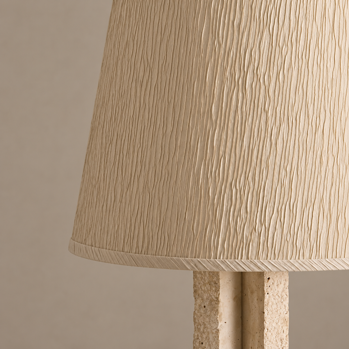 Detail of the CLJFR53 fabric shade’s fine folds and bound edge above the porous travertine.