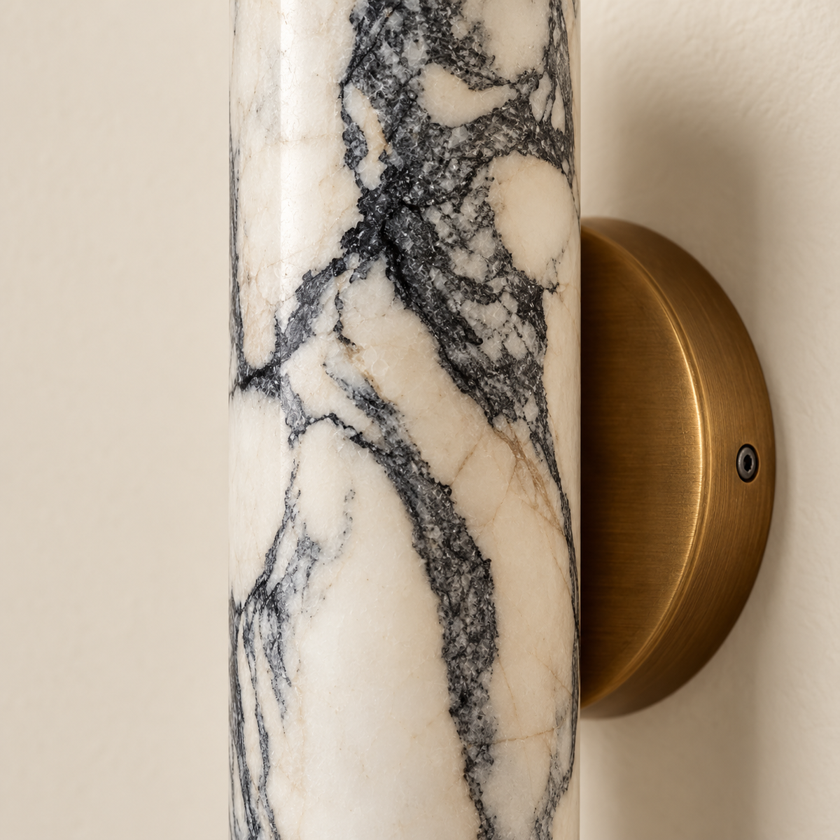 Close-up of the marble cylinder’s grey veining and curved polished stone surface.
