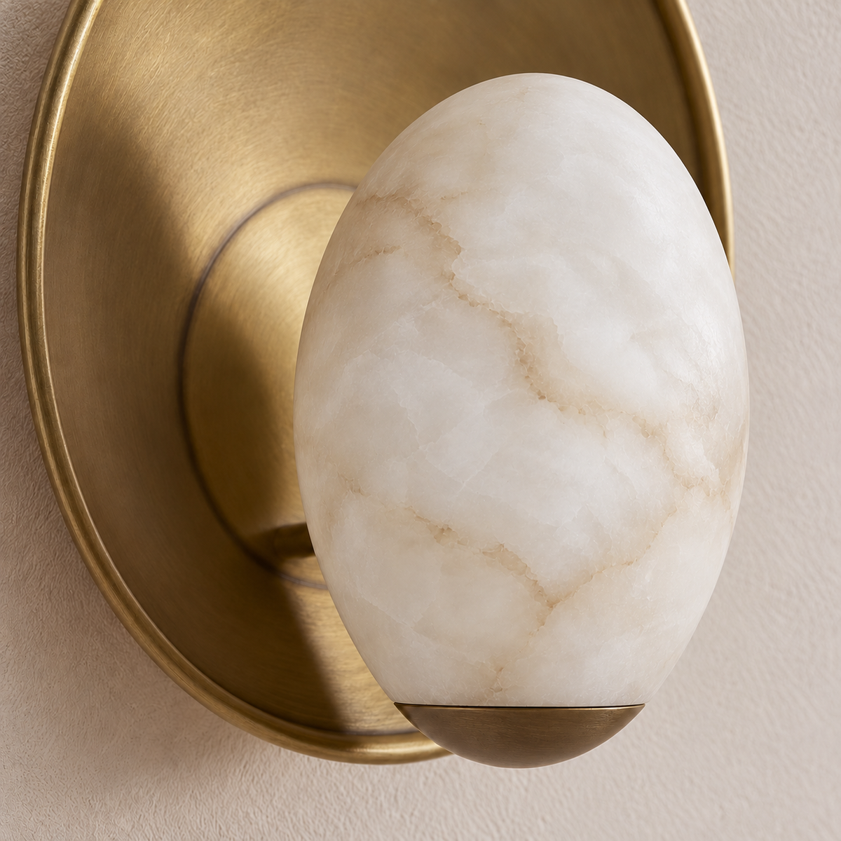 Detail of the carved alabaster egg, small brass support cup and brushed metal rim.