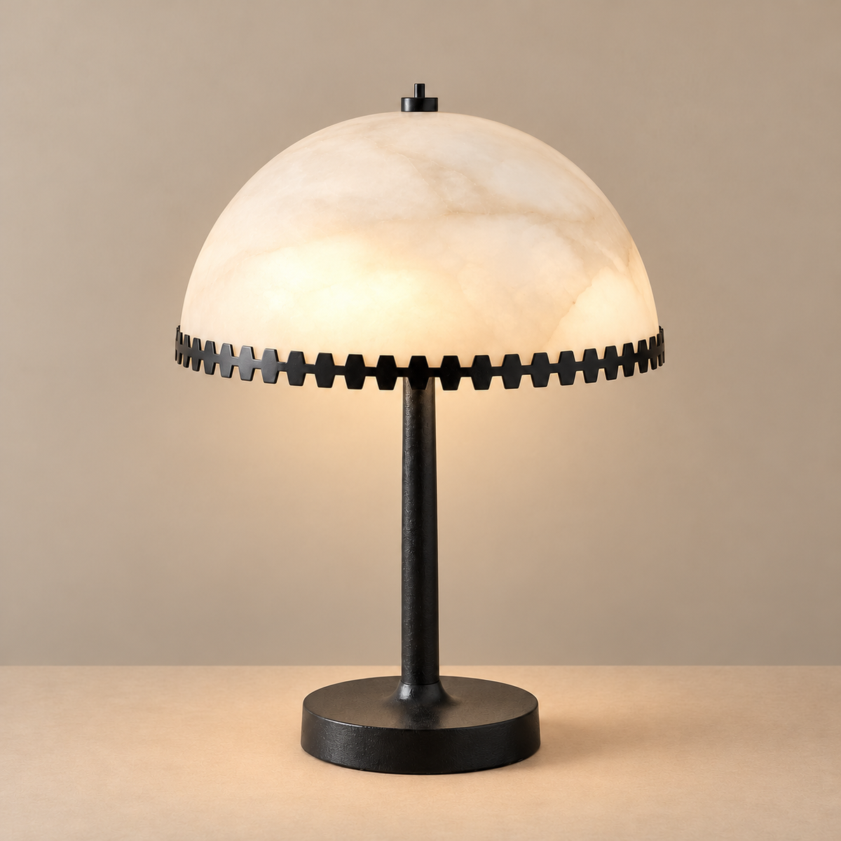 Alabaster dome table lamp with a black metal toothed rim, illuminated on a beige background