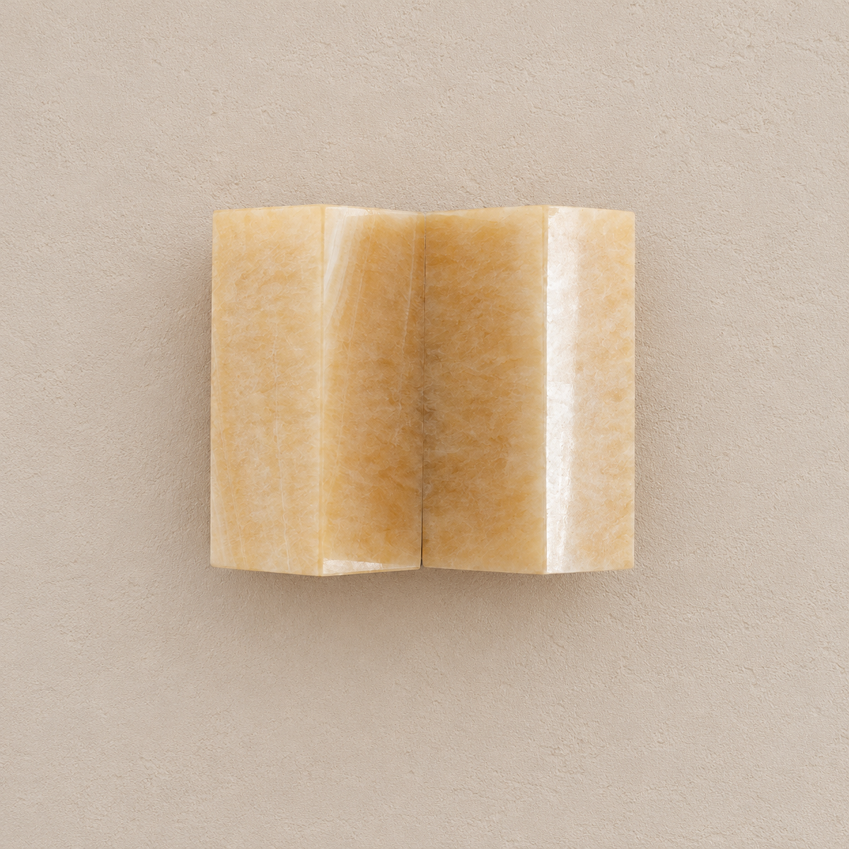 Front view of the CLMZUP jade sconce showing both curved panels, unlit on pale beige.