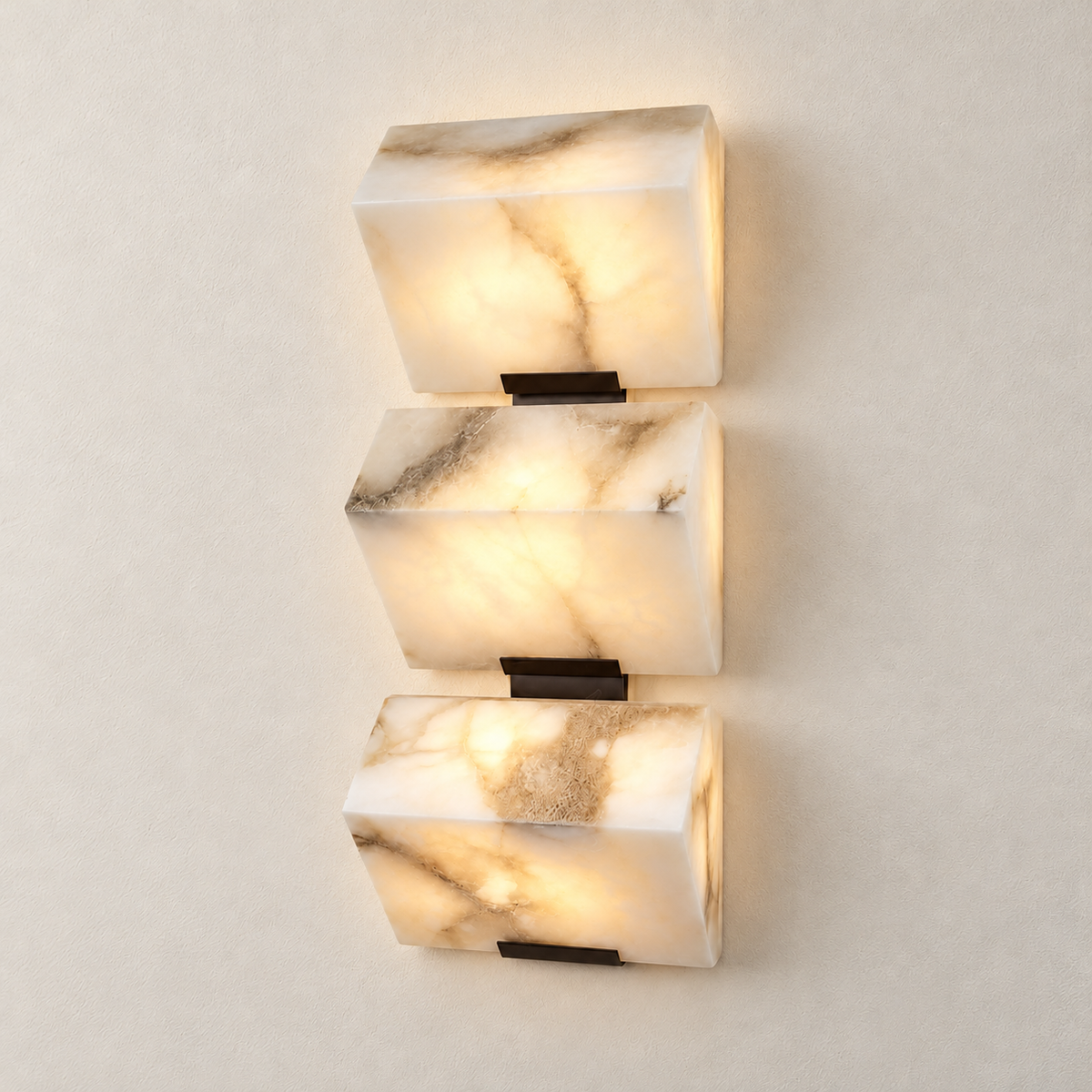 Triple alabaster block wall sconce illuminated through its natural stone.