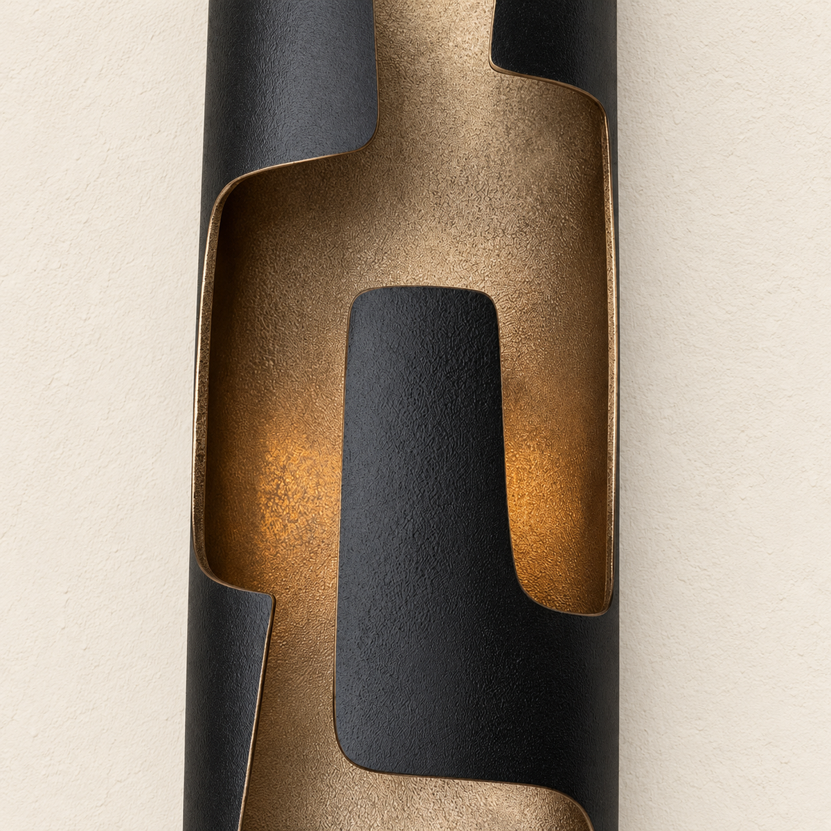 Close-up of the sconce’s dark patinated bronze folds and softly lit inner channel.