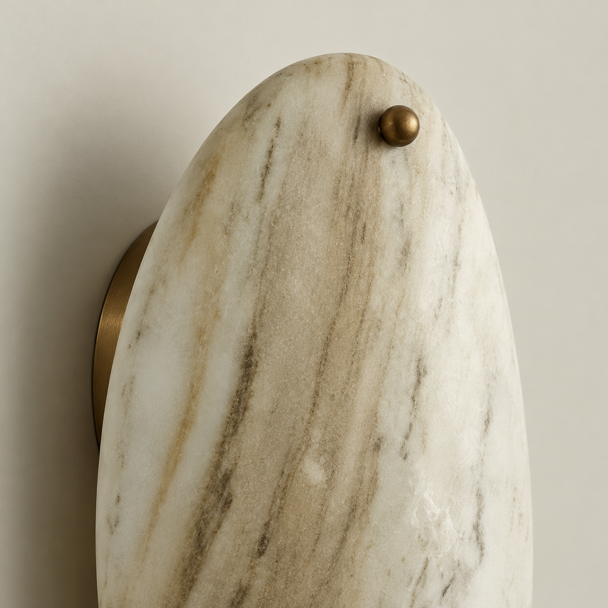 Close-up of pale marble veining and the upper bronze ball fastener.