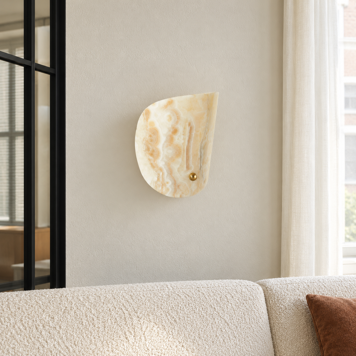 Curved jade wall sconce above a boucle sofa beside a black glass partition.