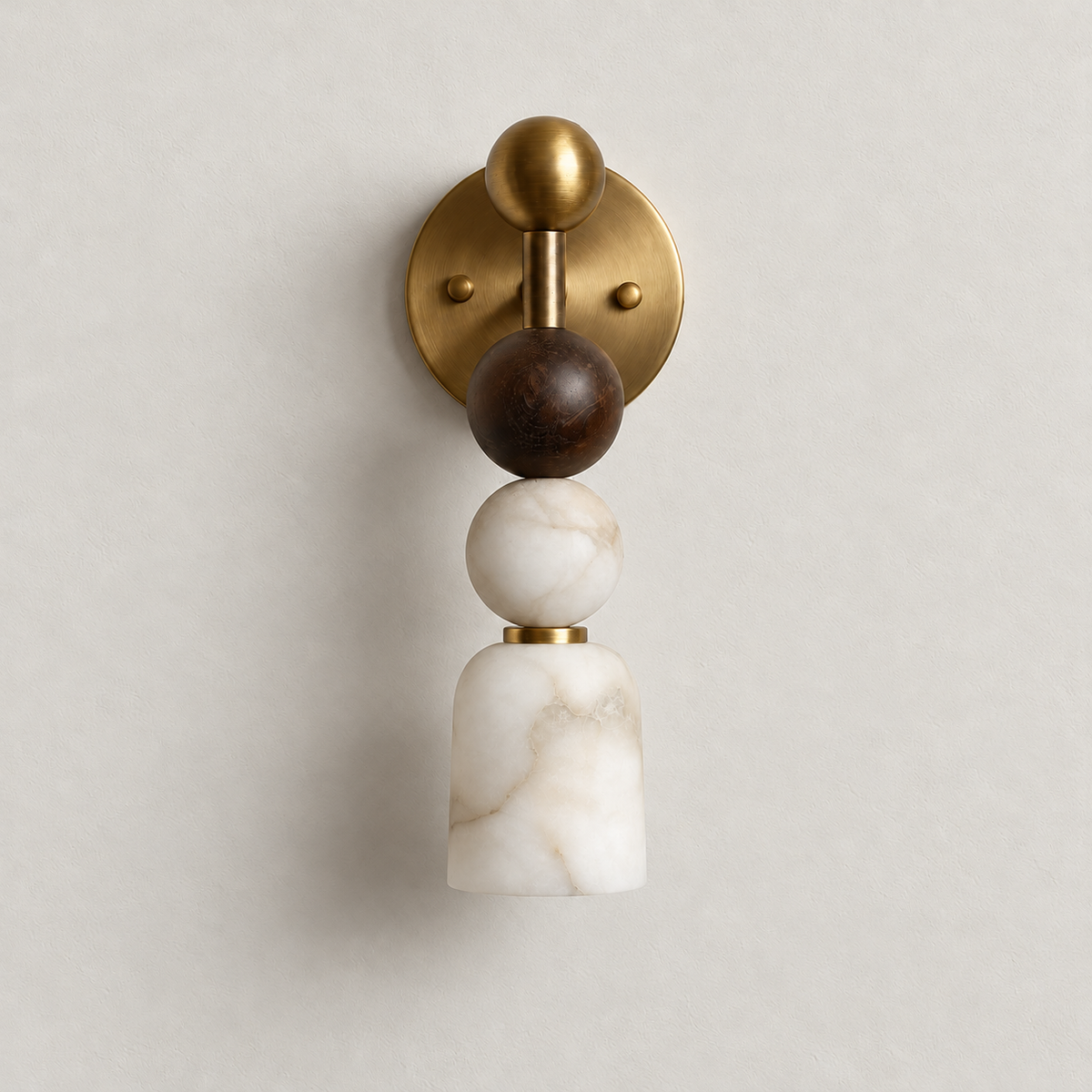 Front view of the unlit alabaster wall sconce with its round brass plate and stacked spheres.