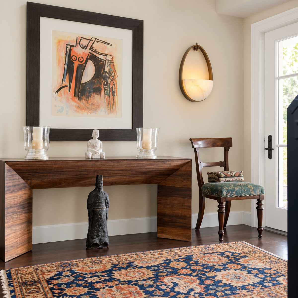 Oval bronze and alabaster sconce installed beside an entryway console.