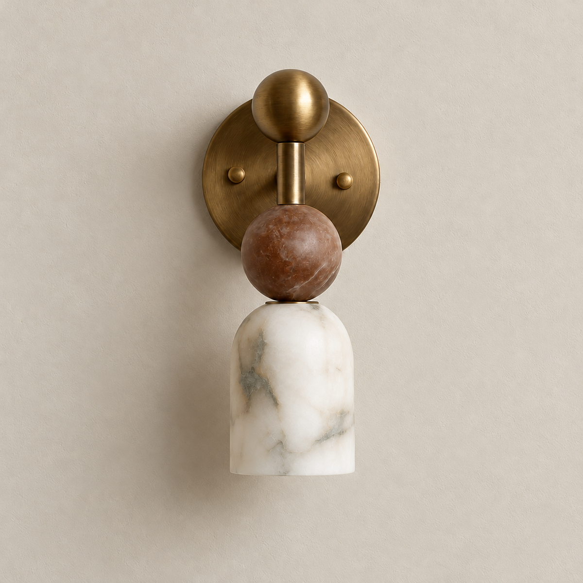 Front view of the Totem Petite brass wall sconce with its round backplate, Rosso marble sphere and alabaster cup.