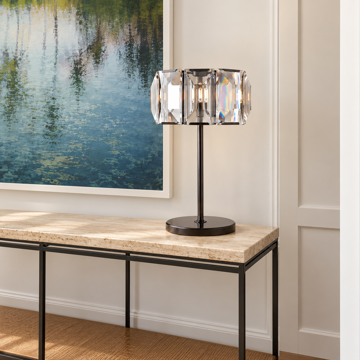 Crystal drum table lamp with a dark metal stem and round base, placed in a console setting