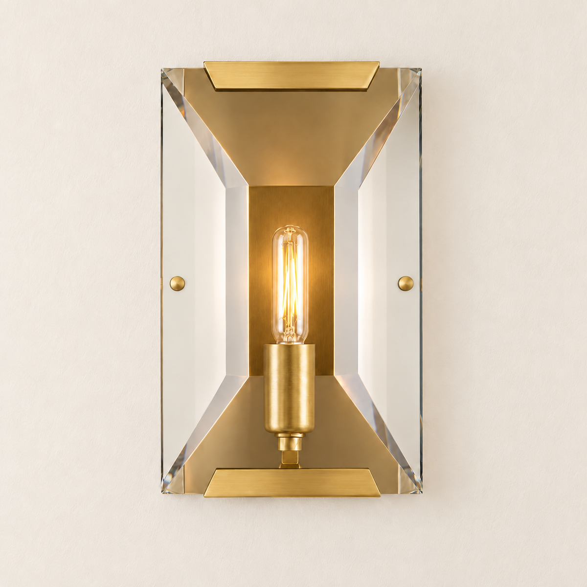 Warm light shines through the beveled crystal panel of the brass wall sconce.