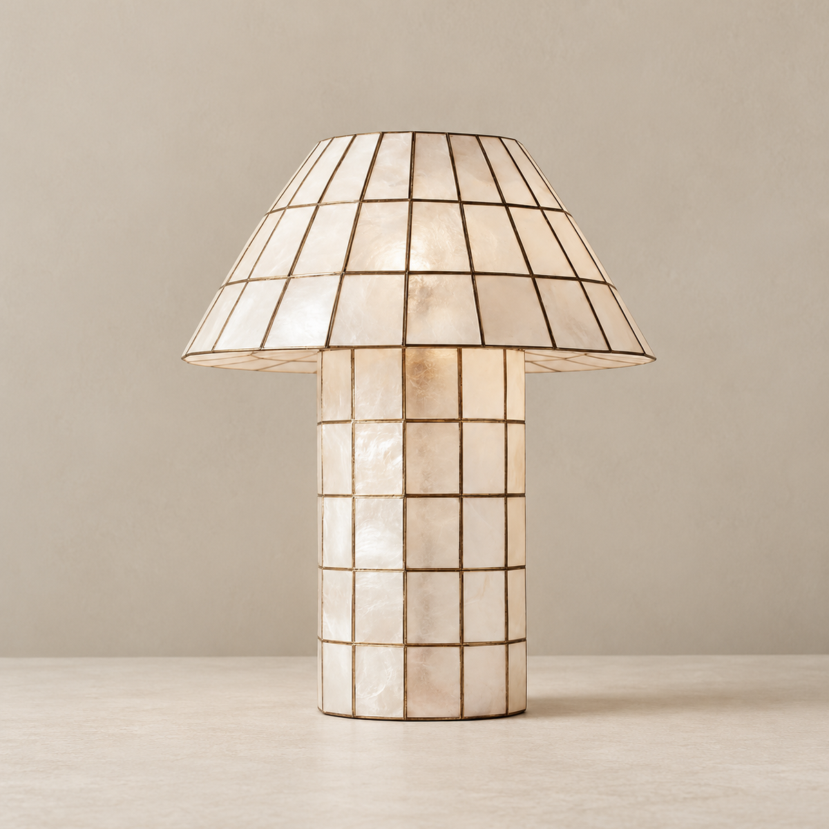 Capiz shell table lamp with a bronze grid, unlit on a beige background