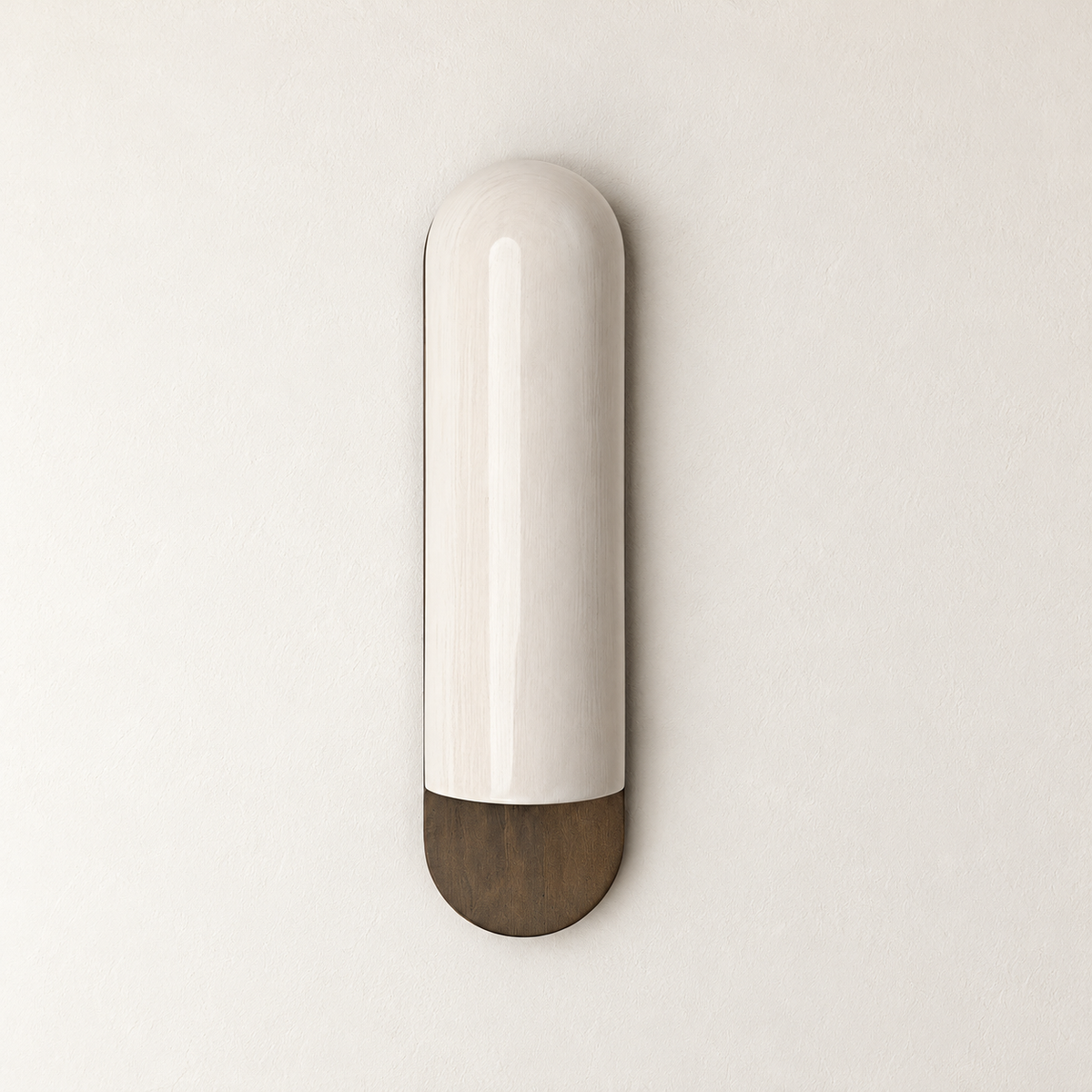 Unlit ivory ceramic wall sconce with a rounded bronze base on warm ivory.