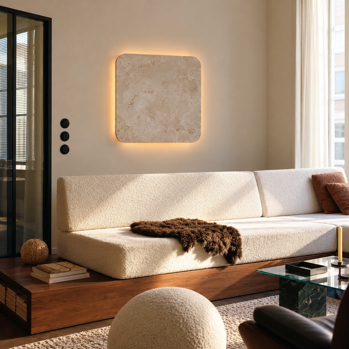 Square travertine wall light above a cream sofa in a modern living room.