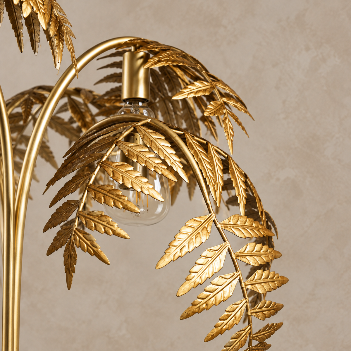 Close-up of serrated gold palm fronds, the curved stem and a replaceable bulb.