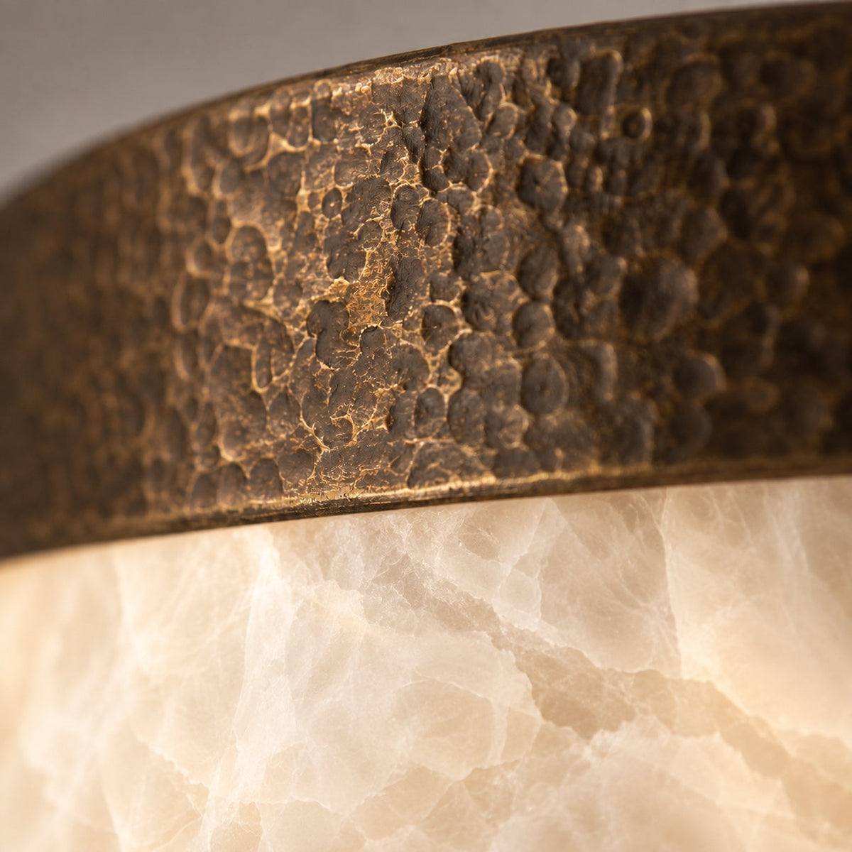 Detail of the hammered antique brass texture on the Linnea alabaster flush mount CLND036-A