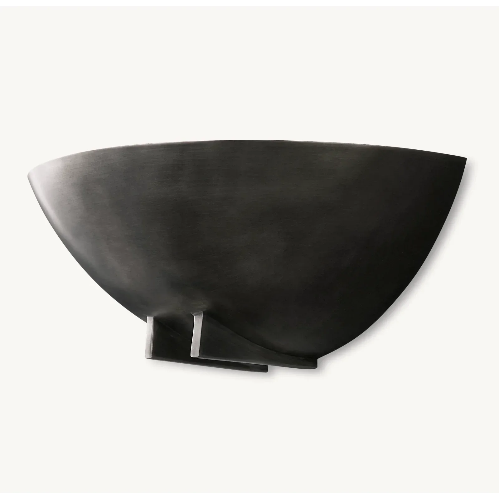 Sculpted black copper bowl sconce glowing warm upward