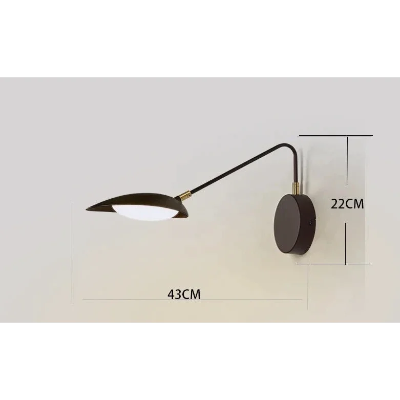 Gold swing-arm wall lamp in a study