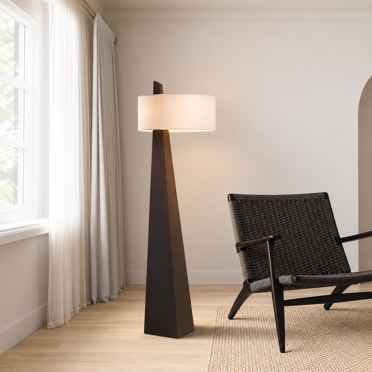 Monolith CLVMO0280 floor lamp beside a woven lounge chair and curtained window.