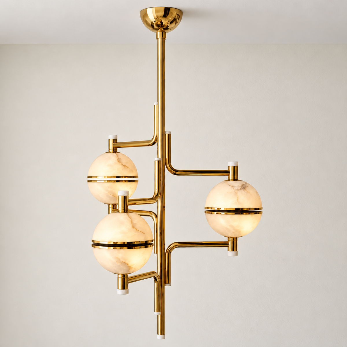 Orbital chandelier illuminated, showing cloudy mineral layers through its three alabaster globes.