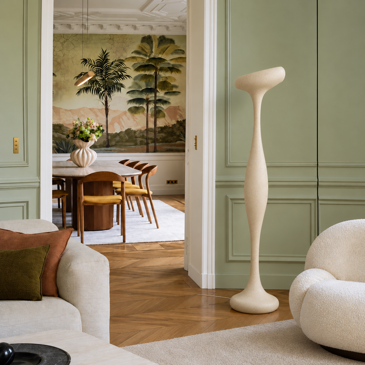 Ostia resin floor lamp beside a rounded cream armchair in a sage-green Parisian living room.