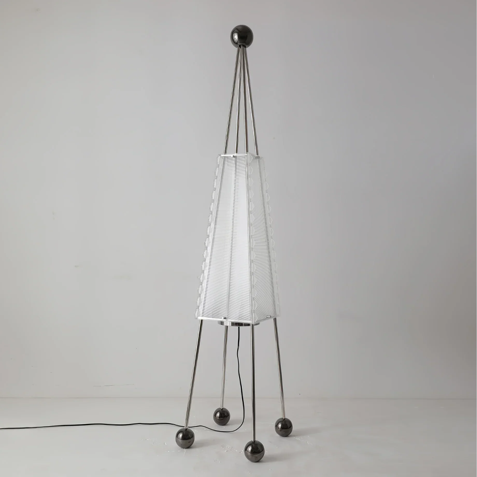 Tent-form steel and acrylic floor lamp in a living room