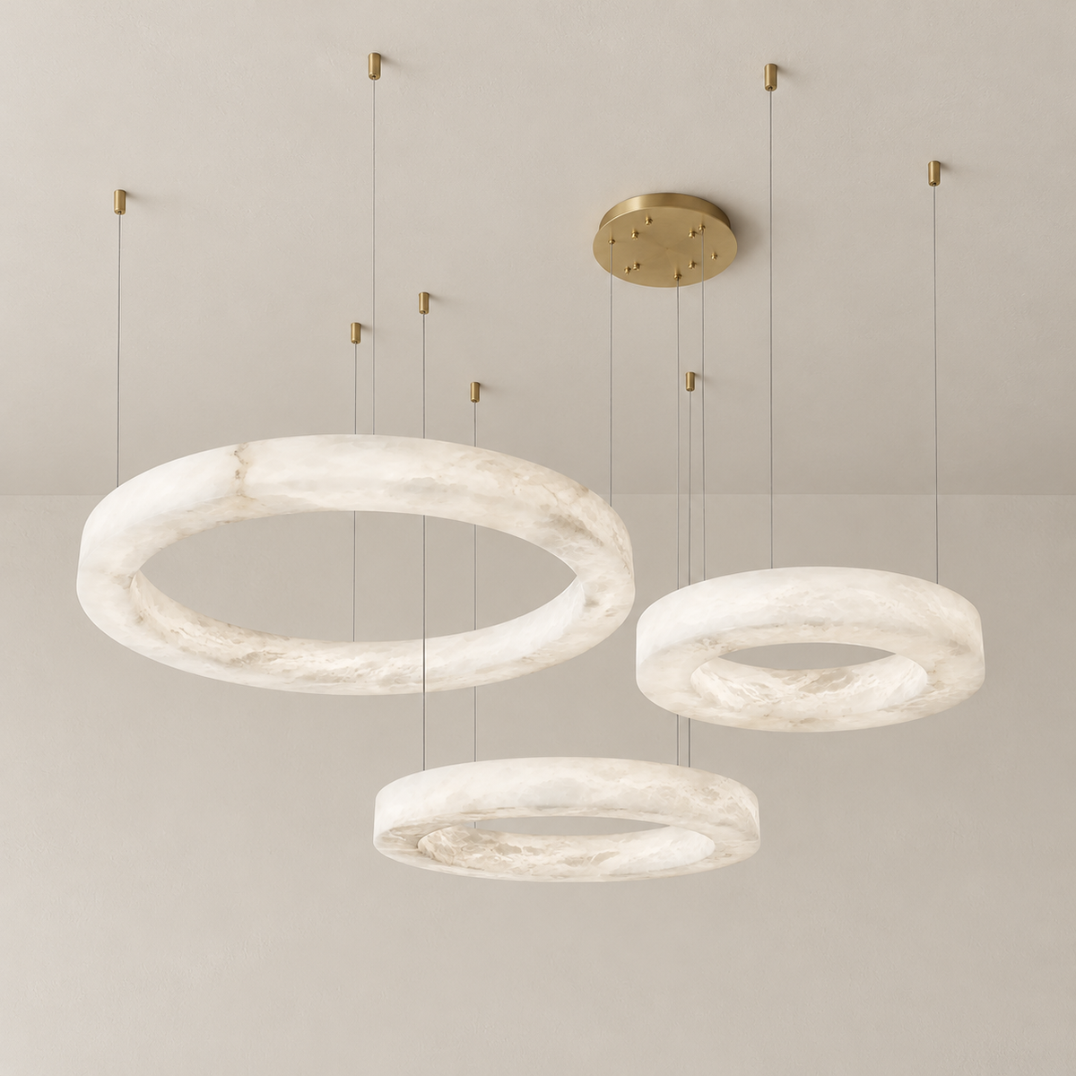 Triplo chandelier unlit, with three staggered alabaster rings and brass ceiling fittings.