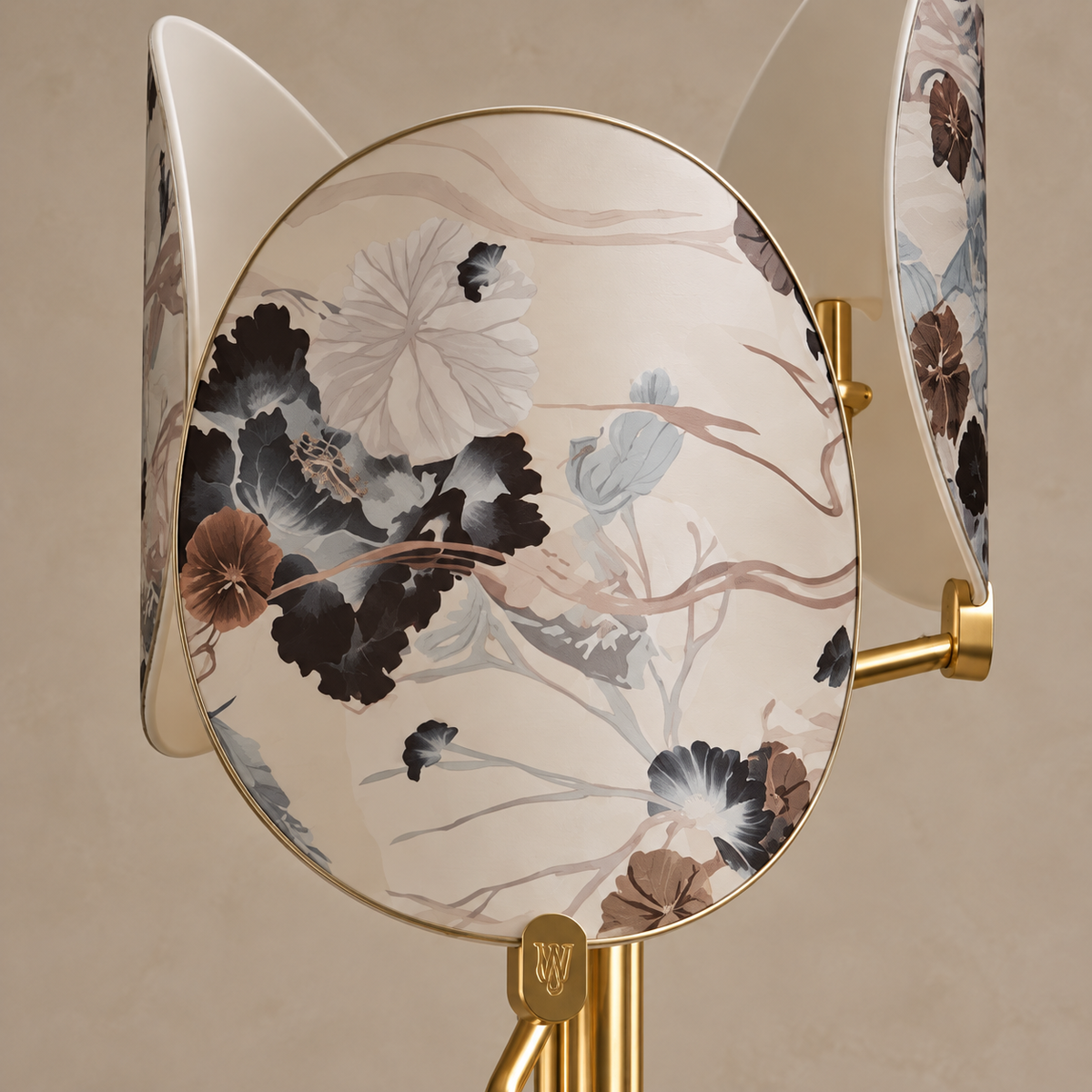 Close-up of a curved floral glass screen, its gold rim and mounting tab.