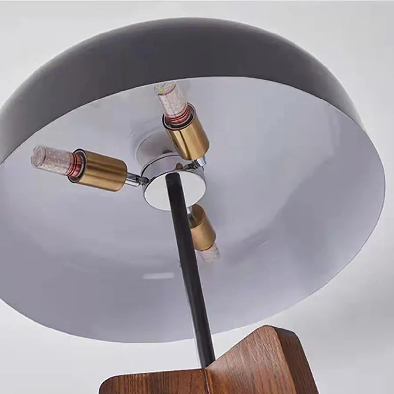 Tripod floor lamp with wooden legs in a reading corner